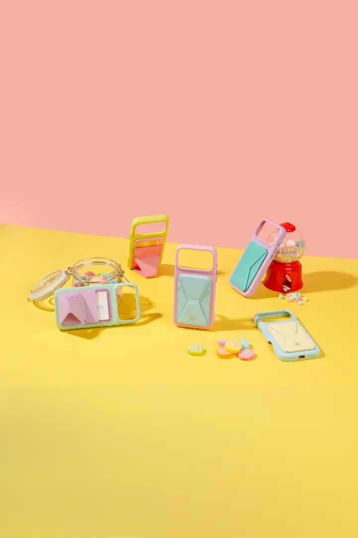 เคสมือถือหลายสีวางกระจายบนพื้นเหลือง